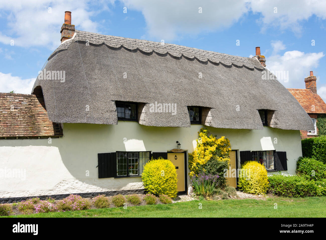 Cottage con il tetto di paglia sul verde, Cuddington, Buckinghamshire, Inghilterra, Regno Unito Foto Stock