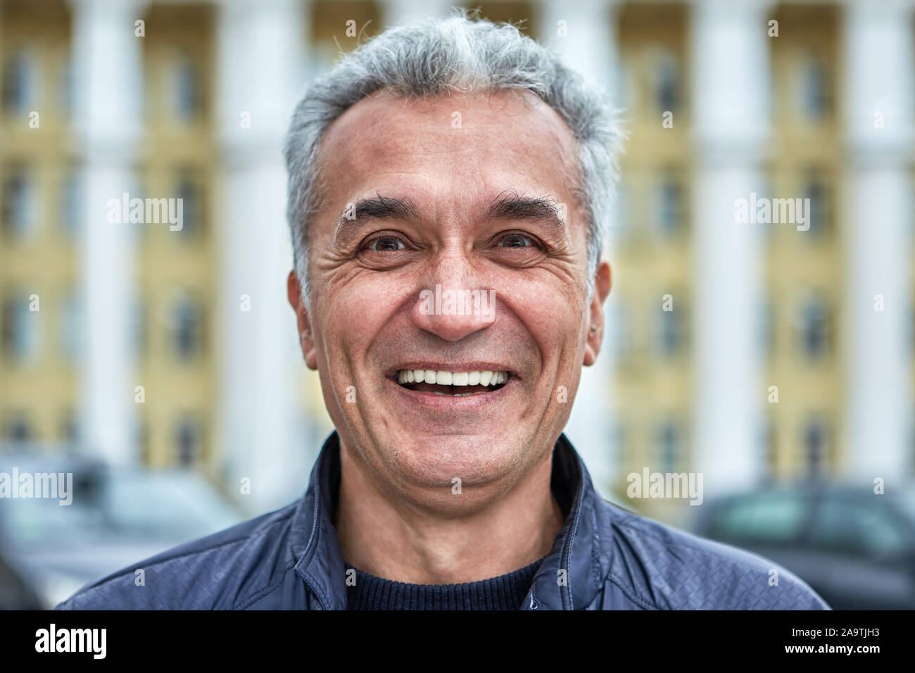 Close-up street ritratto di una gioiosa intelligente di successo uomo di mezza età con delicate caratteristiche del viso. Un maschio di età superiore a 50, guardando come un politi Foto Stock