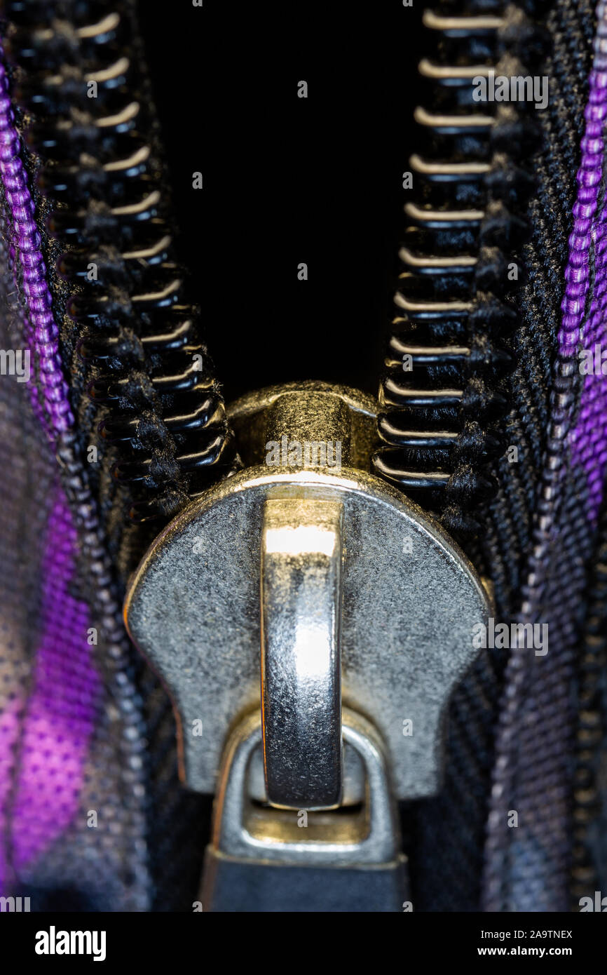 Close-up zip aperto con blocco in metallo e plastica denti. Articoli di abbigliamento Foto Stock