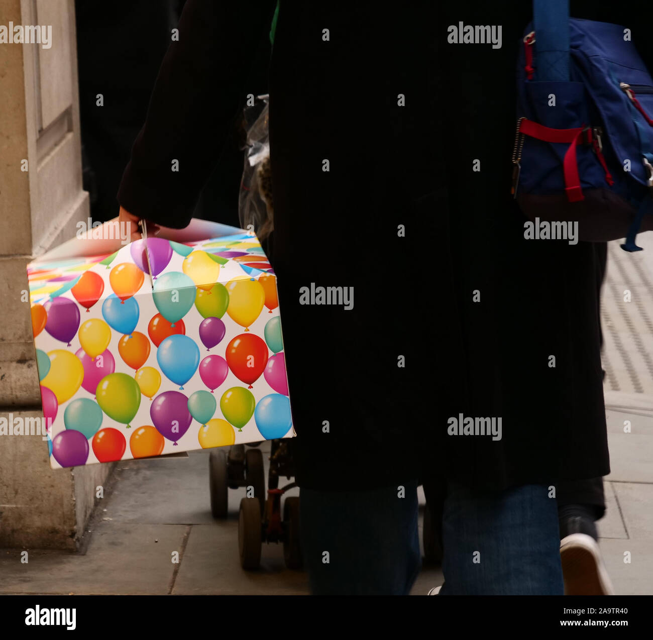 L'uomo visto che porta una scatola colorata con presenta. Foto Stock