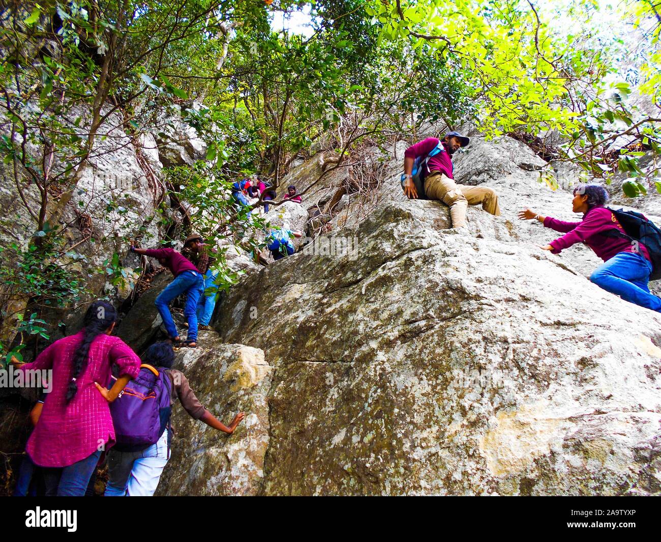 Maggio , 2002, Trincomalee, Sri Lanka , gruppo di adolescenti escursionismo team di giovani escursionisti , climbing una roccia. Aiutando gli uni degli altri Foto Stock