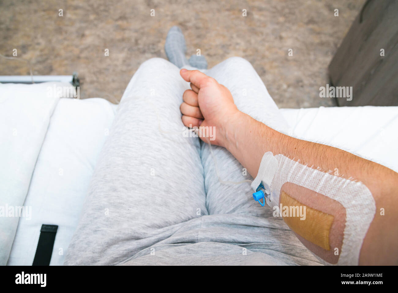 Mano del paziente con il pugno con catetere di infusione. Prospettiva in prima persona Foto Stock