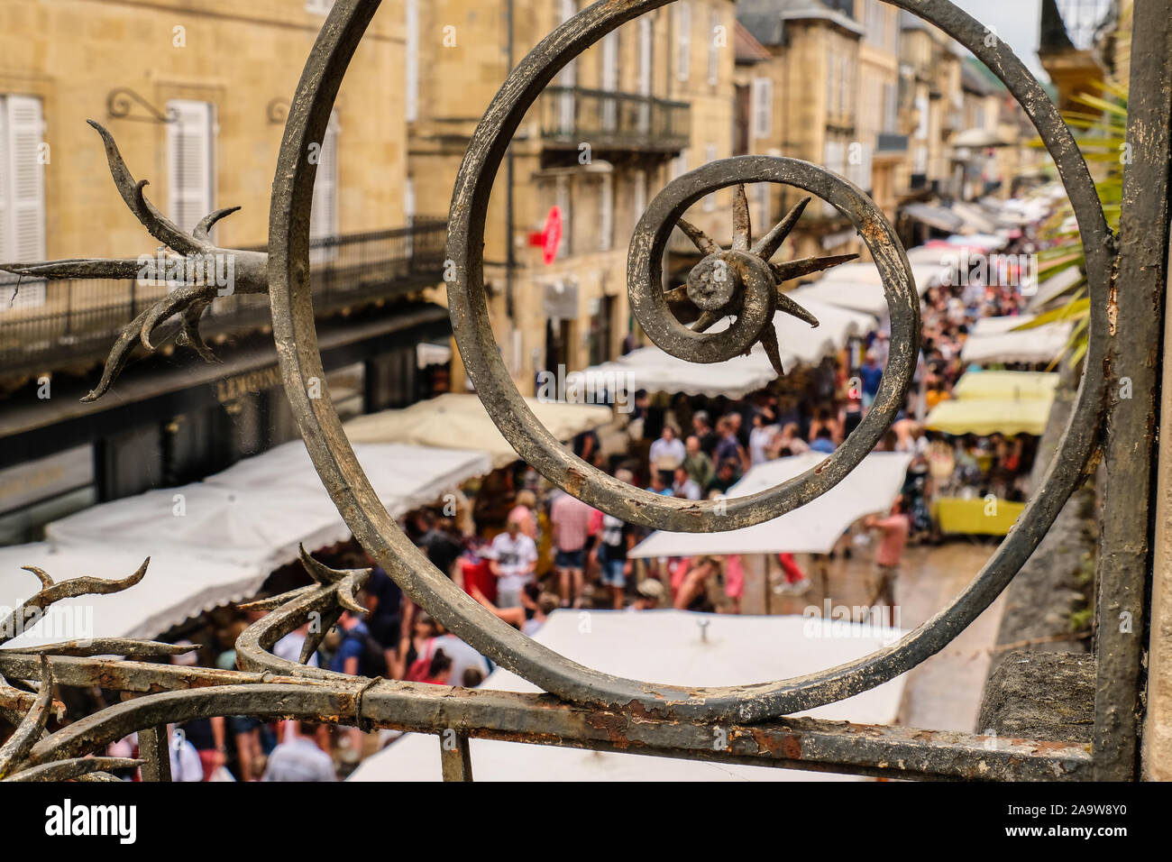 Mercato degli Agricoltori visto attraverso la cancellata in ferro battuto a Sarlat, Francia Foto Stock