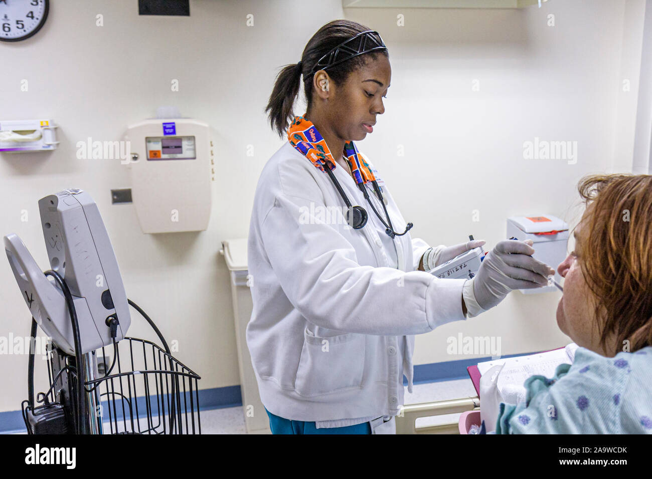Miami Beach Florida, ospedale all'interno della stanza privata del paziente, donna nera donna nutrice termometro misura la temperatura del paziente, Foto Stock