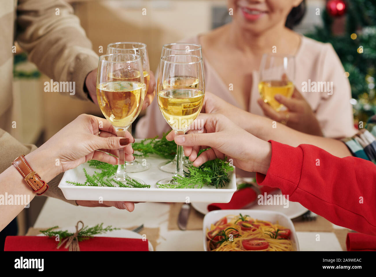 Mani di cena di Natale agli ospiti di prendere champagne formano il vassoio Foto Stock