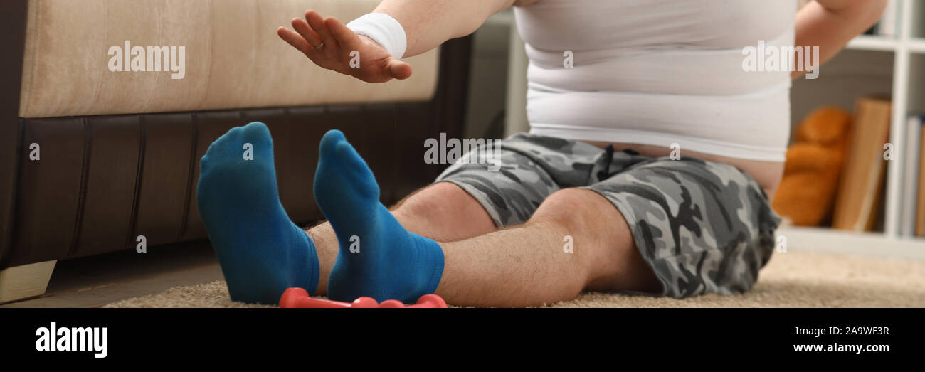 Giovani attraenti uomo fitness giace su un tappeto di grasso con Foto Stock