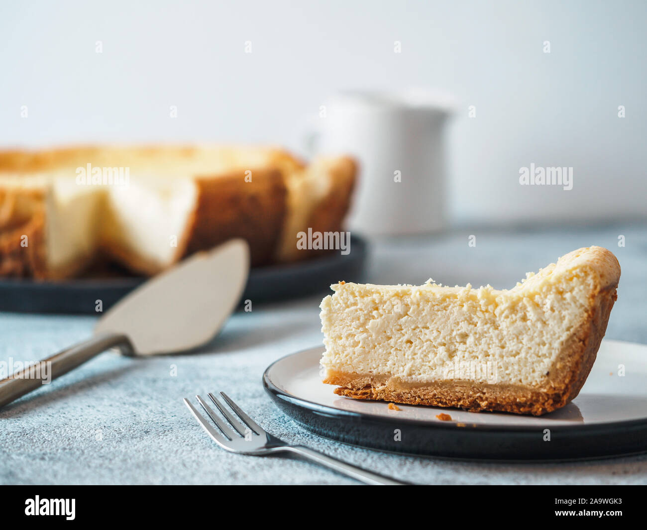 Piastra con il pezzo di cheesecake sul piano portapaziente. In casa classica cheesecake con DOF poco profondo. Copia spazio per il testo. Foto Stock