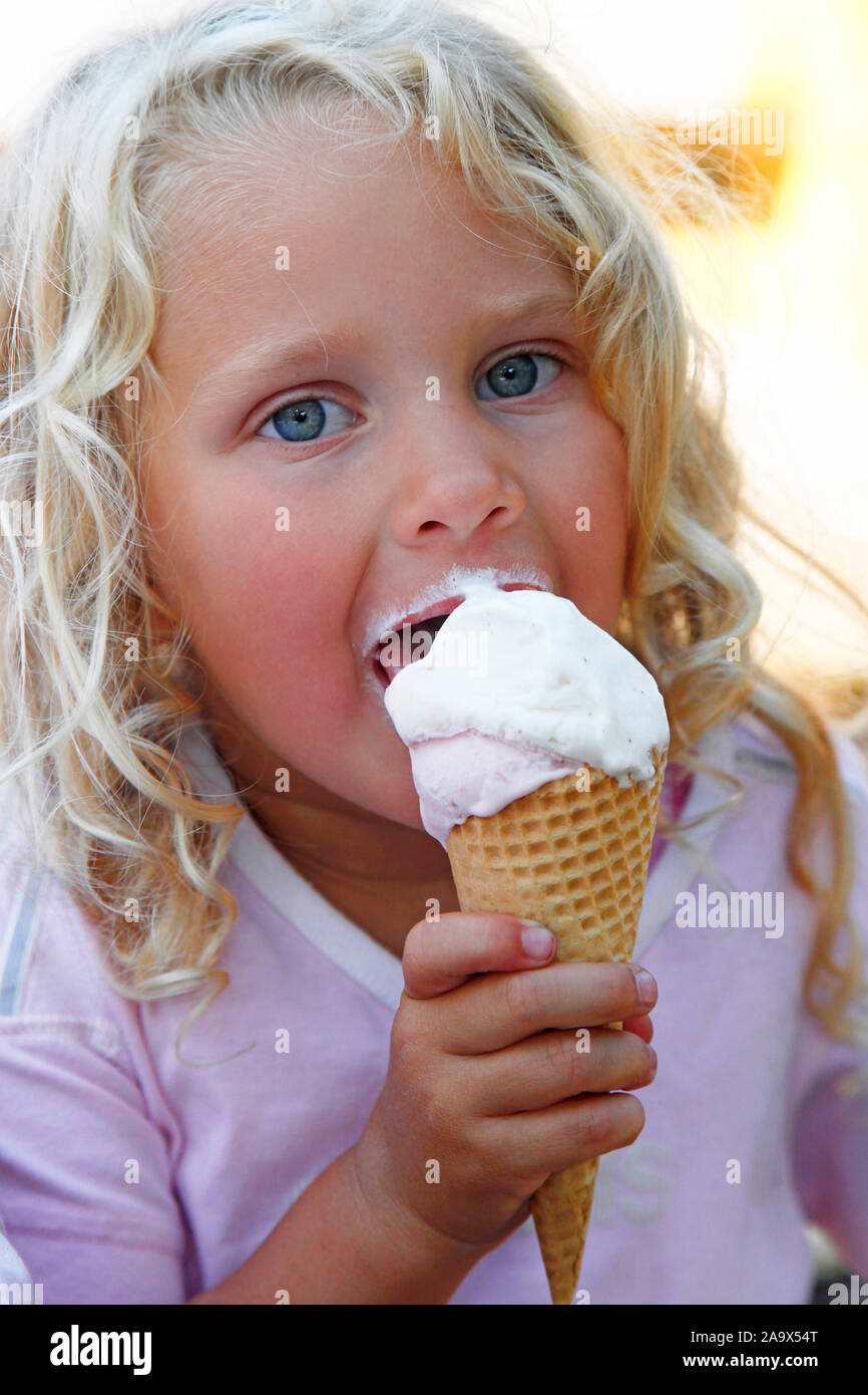 Bionde Maedchen im Sommer geniesst ihr Vanilleeis Foto Stock