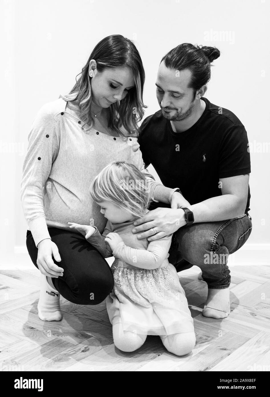 Gravidanza mamma e papà con la figlia di due anni lifestyle UK Foto Stock