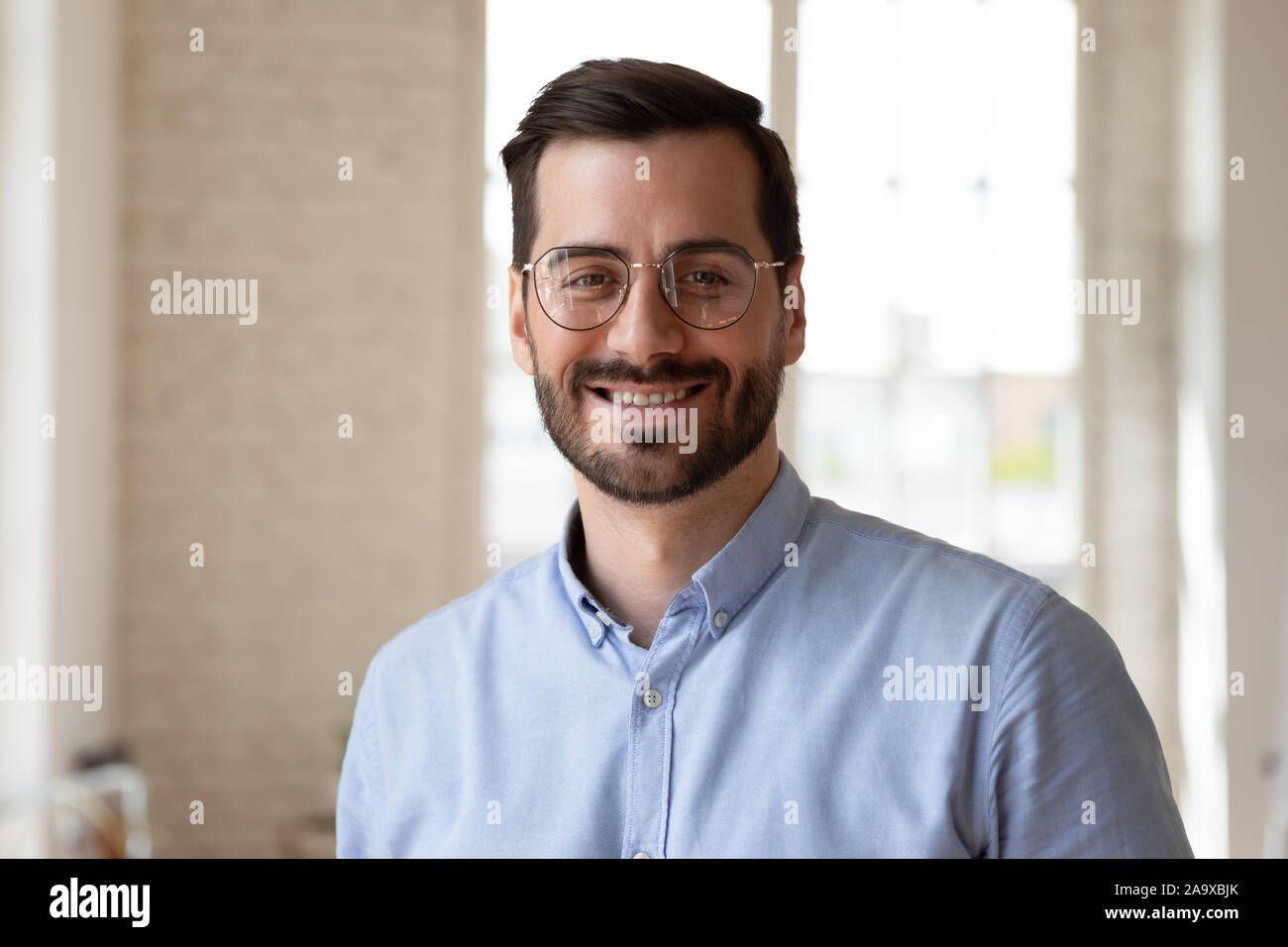 Colpo alla testa close up ritratto giovane imprenditore sorridente. Foto Stock