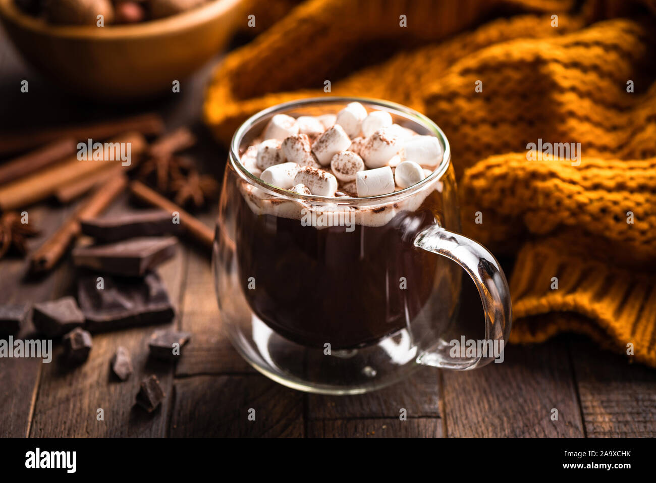 Cioccolata calda e marshmallows in tazza di vetro su un tavolo di legno. Dark moody cibo foto Foto Stock