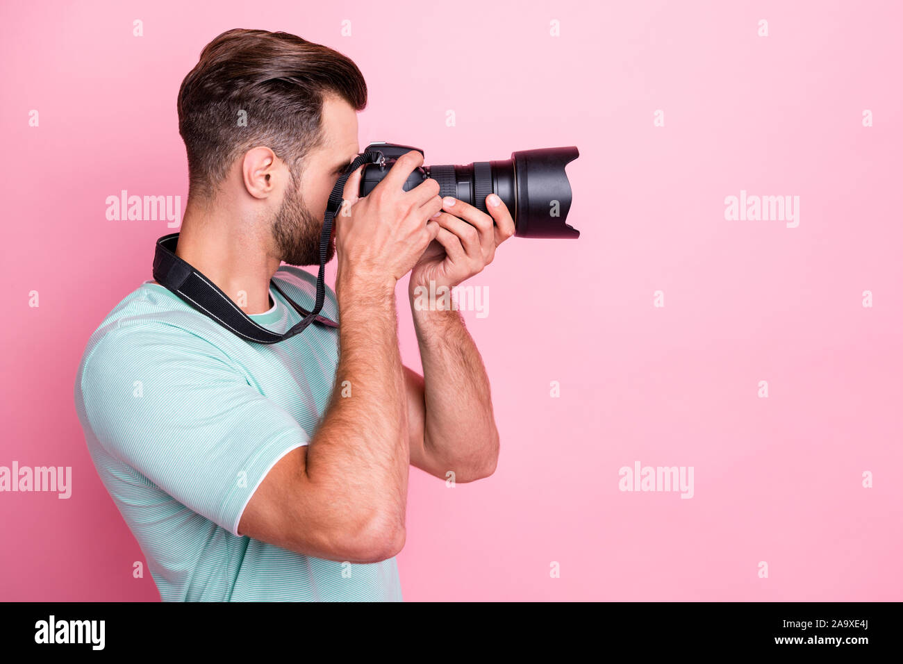 Profilo foto a lato del concentrato uomo fotografo freelance relax vacanza di primavera prendendo foto professionali di tenere la fotocamera DSLR indossare abbigliamento moderno Foto Stock