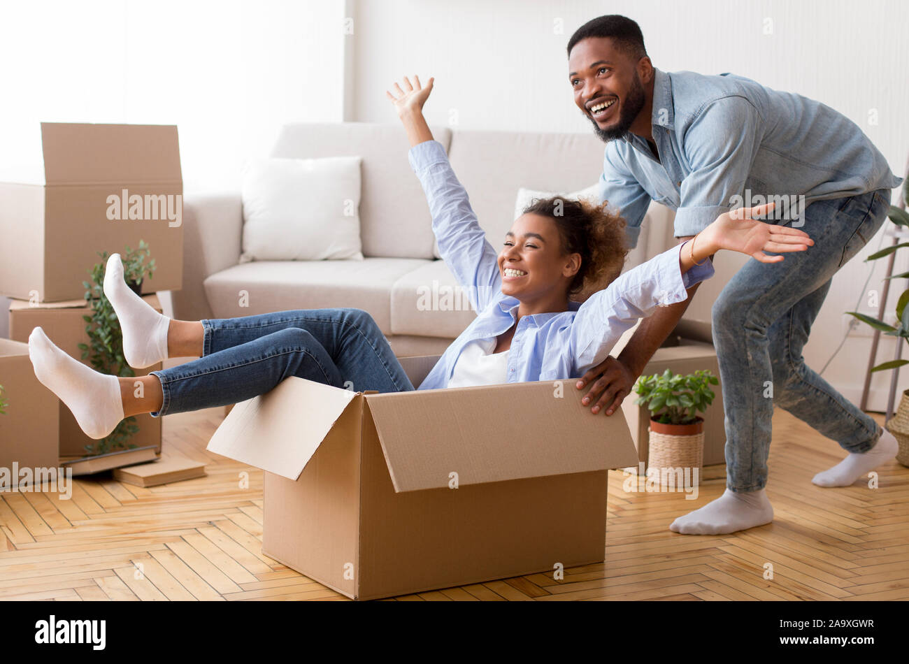 Afro marito Moglie di equitazione in scatola di movimentazione nella nuova casa Foto Stock