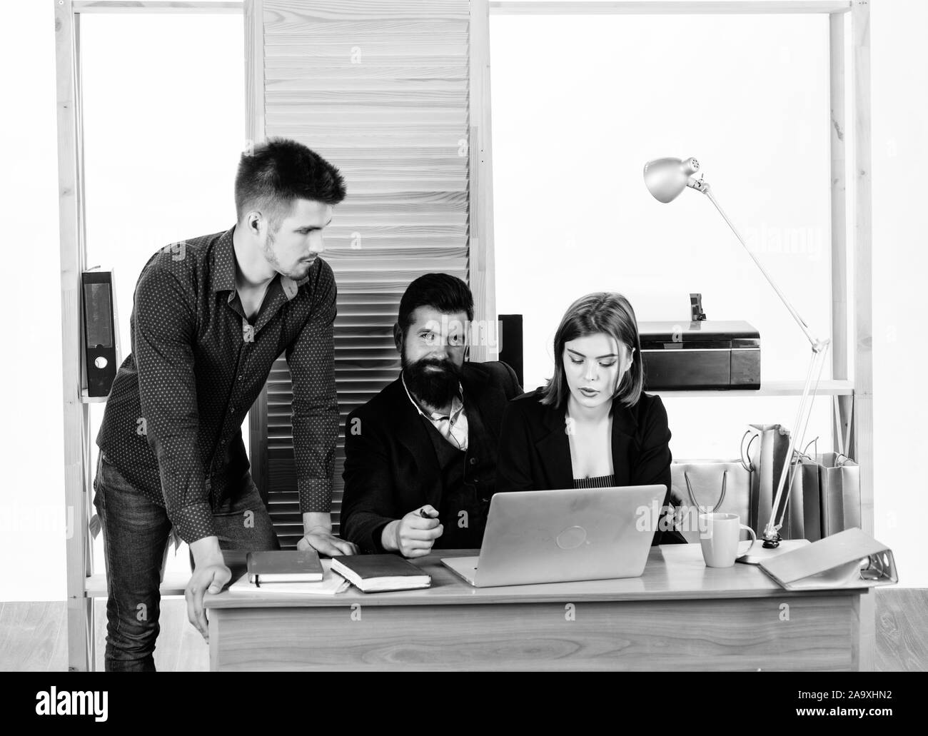 I colleghi di comunicare la risoluzione di attività aziendali. Lavorando insieme. Gestione del processo. Lavorando in prevalenza maschile lavoro. Donna attraente dama di lavorare con colleghi uomini. Ufficio concetto collettivo. Foto Stock