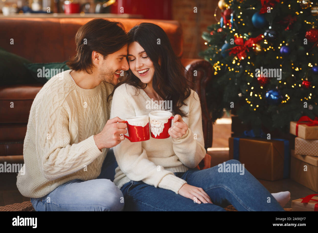Matura in amore con il cacao accanto a albero di Natale Foto Stock