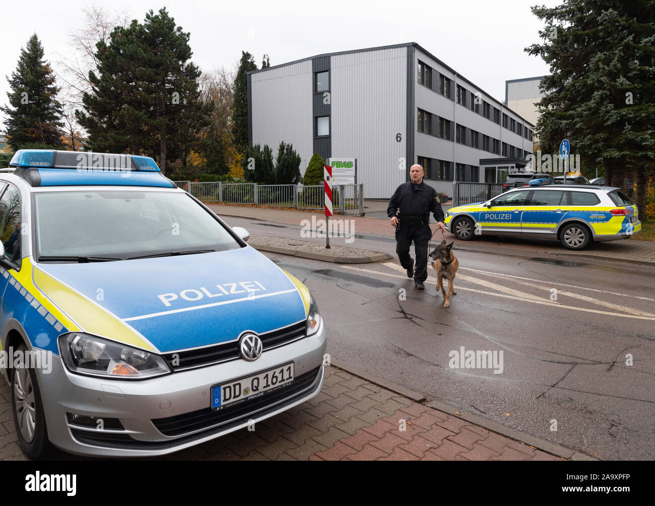 Brand Erbisdorf, Germania. Xviii Nov, 2019. Un poliziotto lascia Brand-Erbisdorf (FBAB) con il suo cane poliziotto alla formazione e formazione professionale Academy GmbH. La scuola di formazione professionale nel centro città sassone di Brand-Erbisdorf è stato evacuato il lunedì dopo una minaccia. Credito: Robert Michael/dpa-Zentralbild/dpa/Alamy Live News Foto Stock