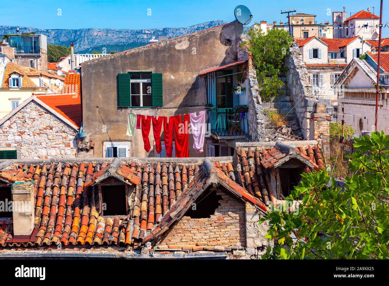 Accogliente casa vecchia con verde di persiane alle finestre e luminosa biancheria all'interno di Palazzo Diocleziano nella Città Vecchia di Spalato, la seconda città più grande della Croazia Foto Stock