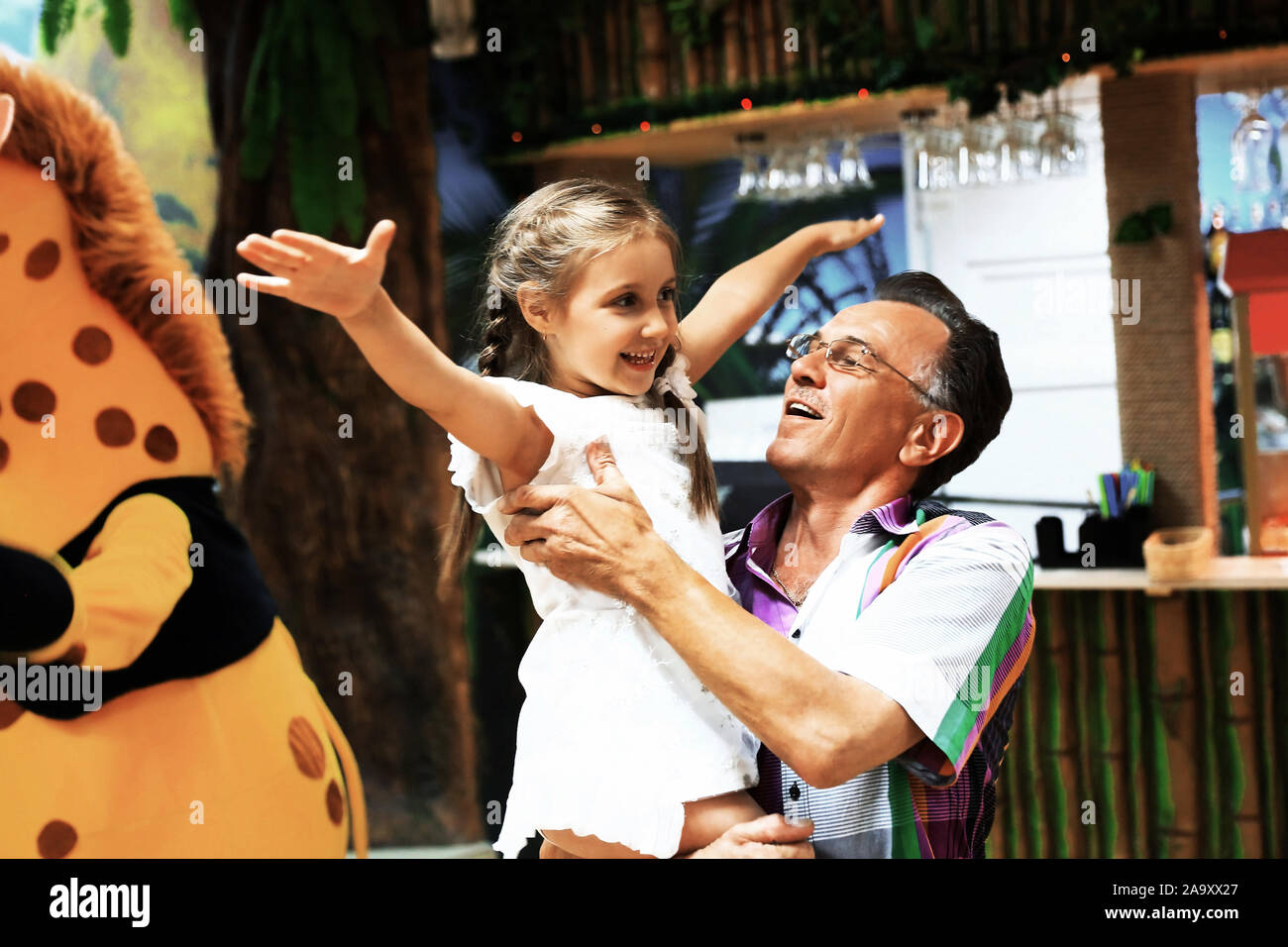 Nonno giocando con il nipote in un centro di intrattenimento Foto Stock