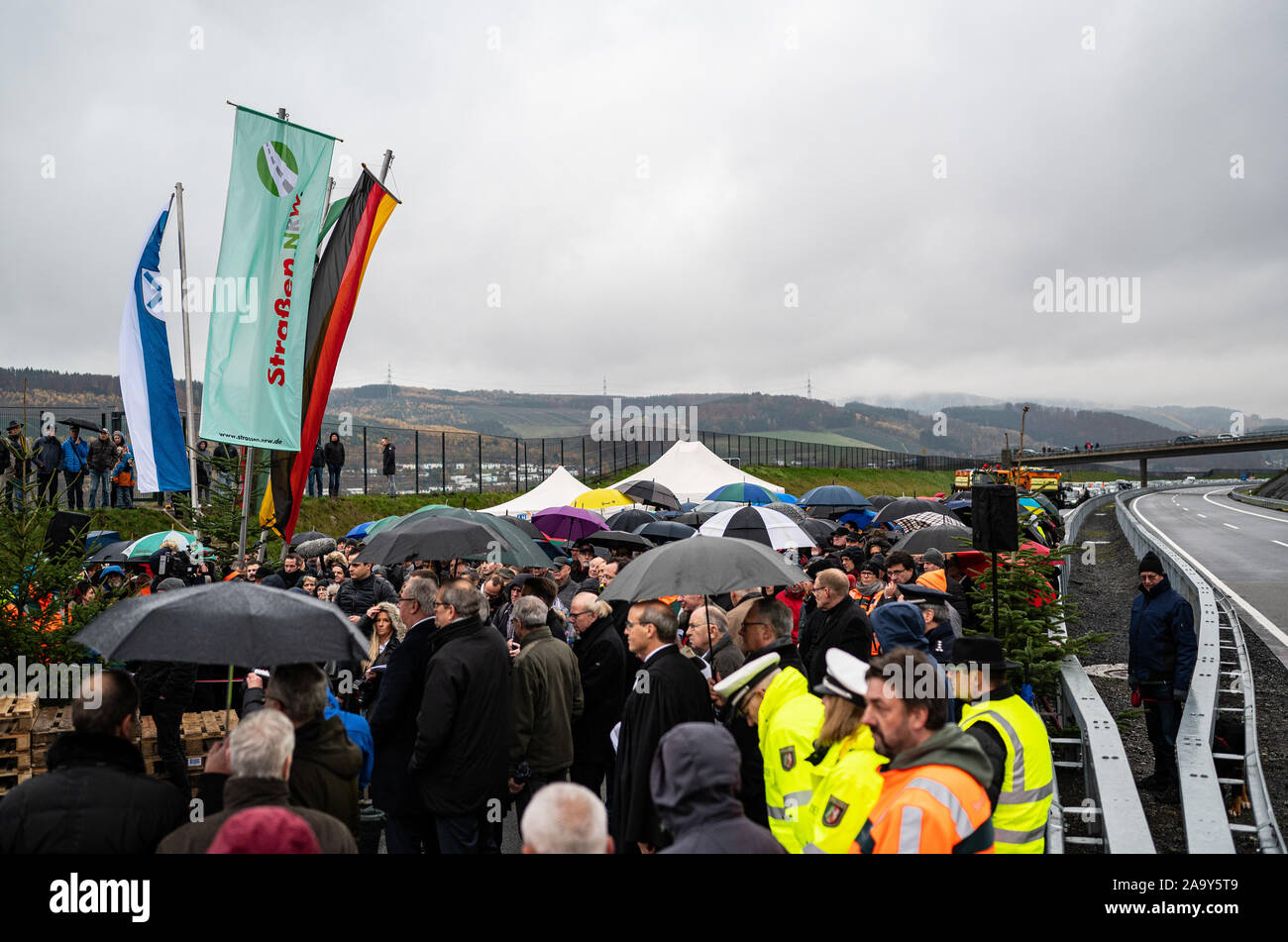 Bestwig, Germania. Xviii Nov, 2019. Presso il cerimoniale di apertura del più alto ponte autostradale in NRW, numerose persone in piedi sulla A46 vicino Bestwig. Il ponte di valle Nuttlar è il completamento di un ponte a valle nel corso dell'autostrada federale 46 nel Sauerland. Con un altezza di 115 metri, è il ponte più alto nella Renania settentrionale-Vestfalia. Oggi la sezione dell'autostrada 46 e il ponte sono stati ufficialmente inaugurato e aperto al traffico. Credito: Guido Kirchner/dpa/Alamy Live News Foto Stock