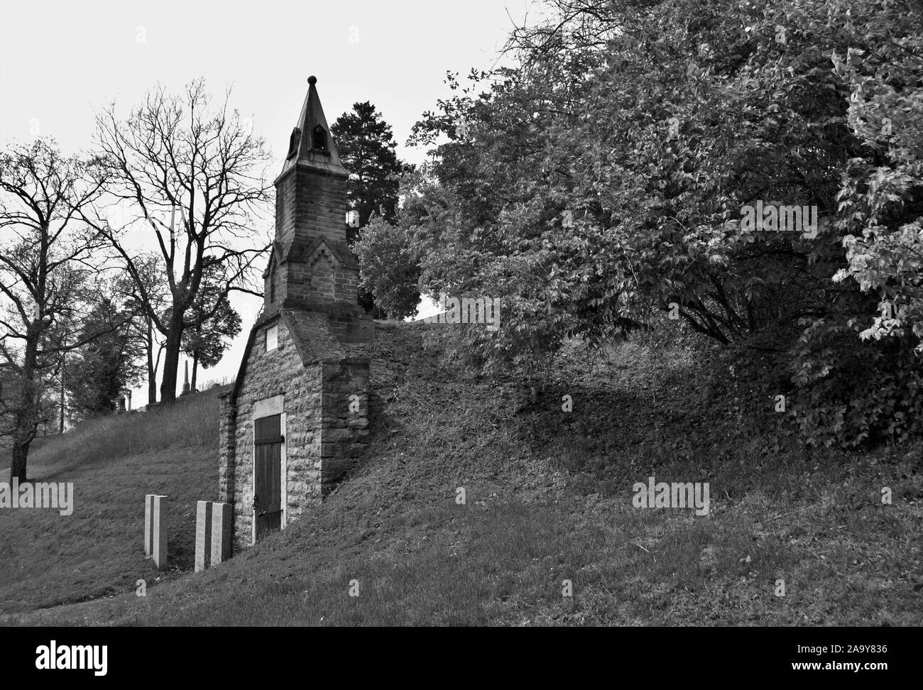 Molto vecchio mausoleo costruito sul fianco di una collina con steeple, lapidi, e ferro battuto recinzione Foto Stock