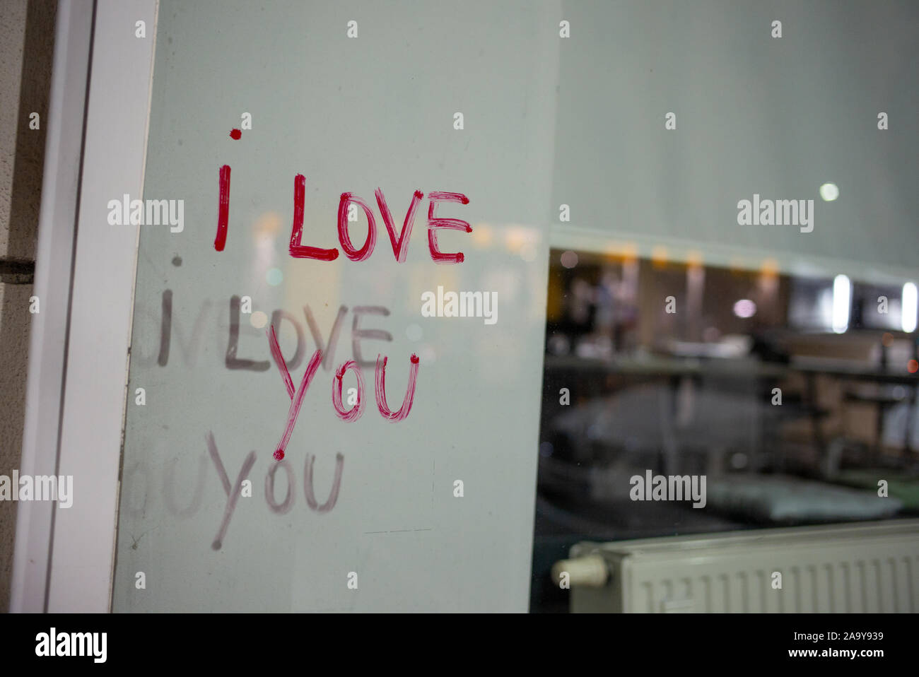 "Ti amo" scritto graffiti sul vetro della finestra di un negozio, eventualmente in un rossetto, di notte a Vienna, in Austria Foto Stock