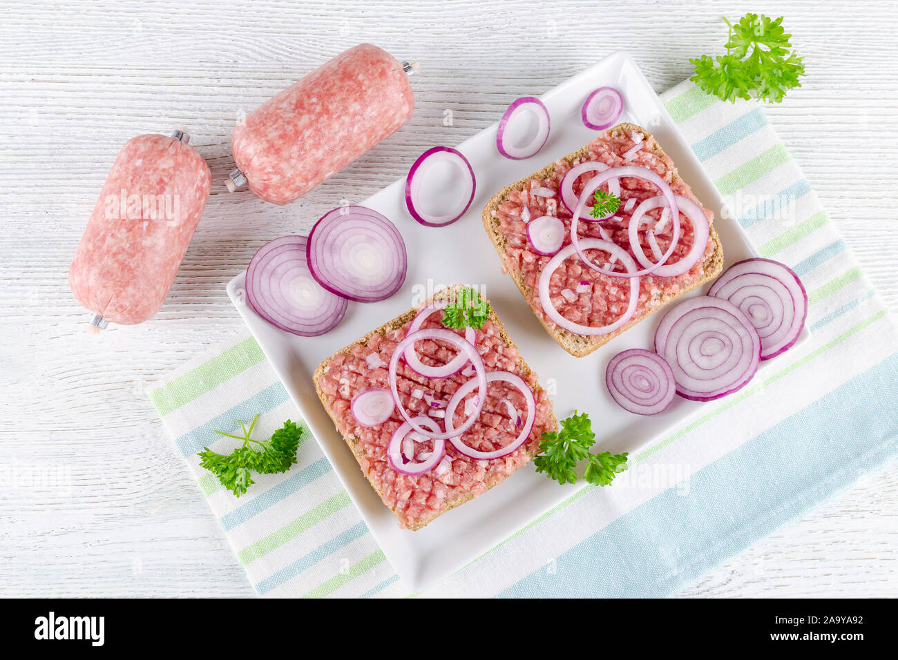 Sandwich tedesco mettbrotchen la carne macinata di maiale, bun e carne cruda con la cipolla e il prezzemolo Foto Stock