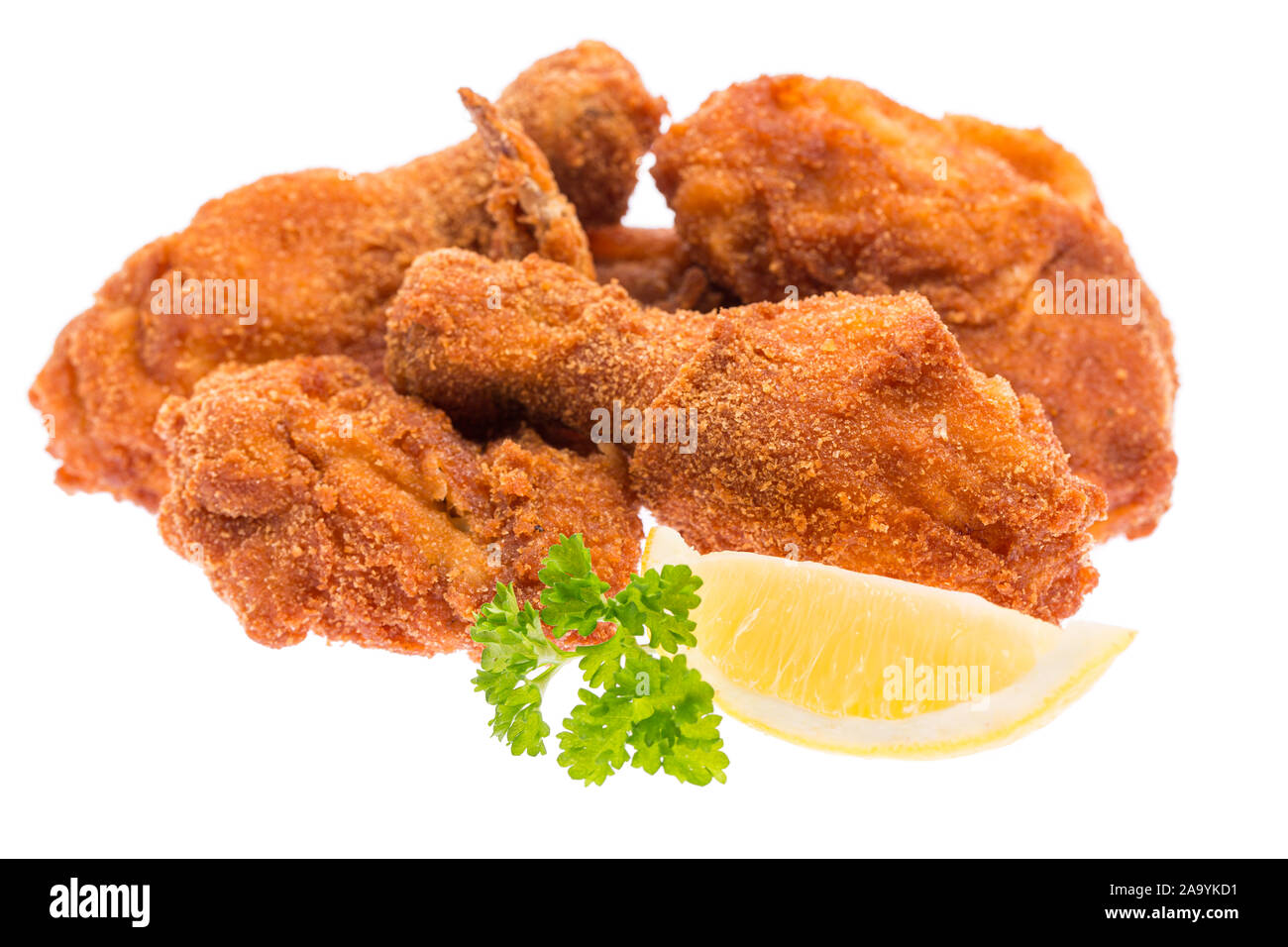 Fritto di pollo a pezzi con limone e prezzemolo isolati su sfondo bianco Foto Stock