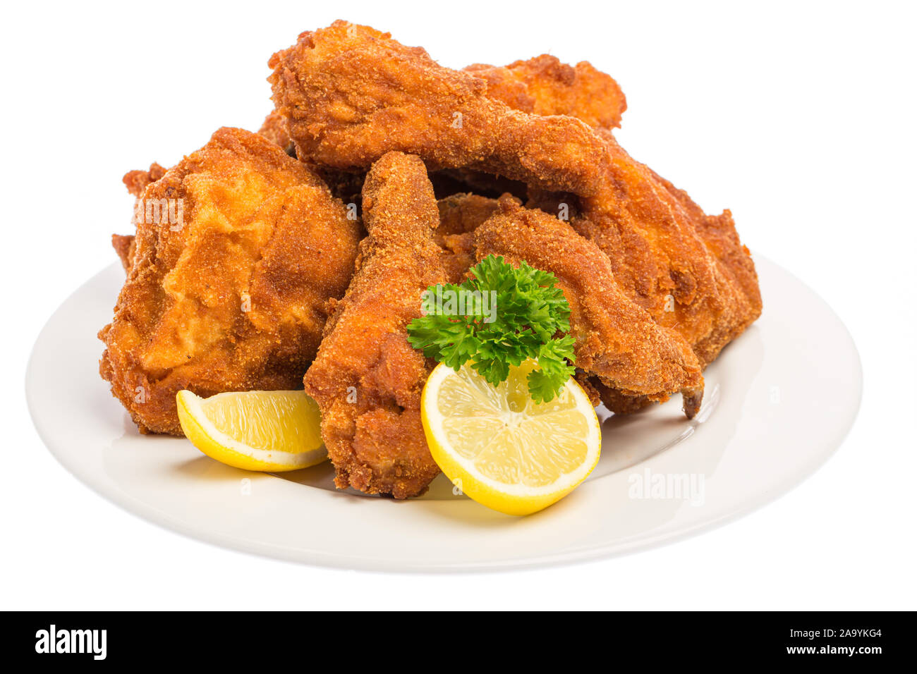 Grande lastra con molti fritto di pollo a pezzi con le fette di limone e prezzemolo isolati su sfondo bianco Foto Stock