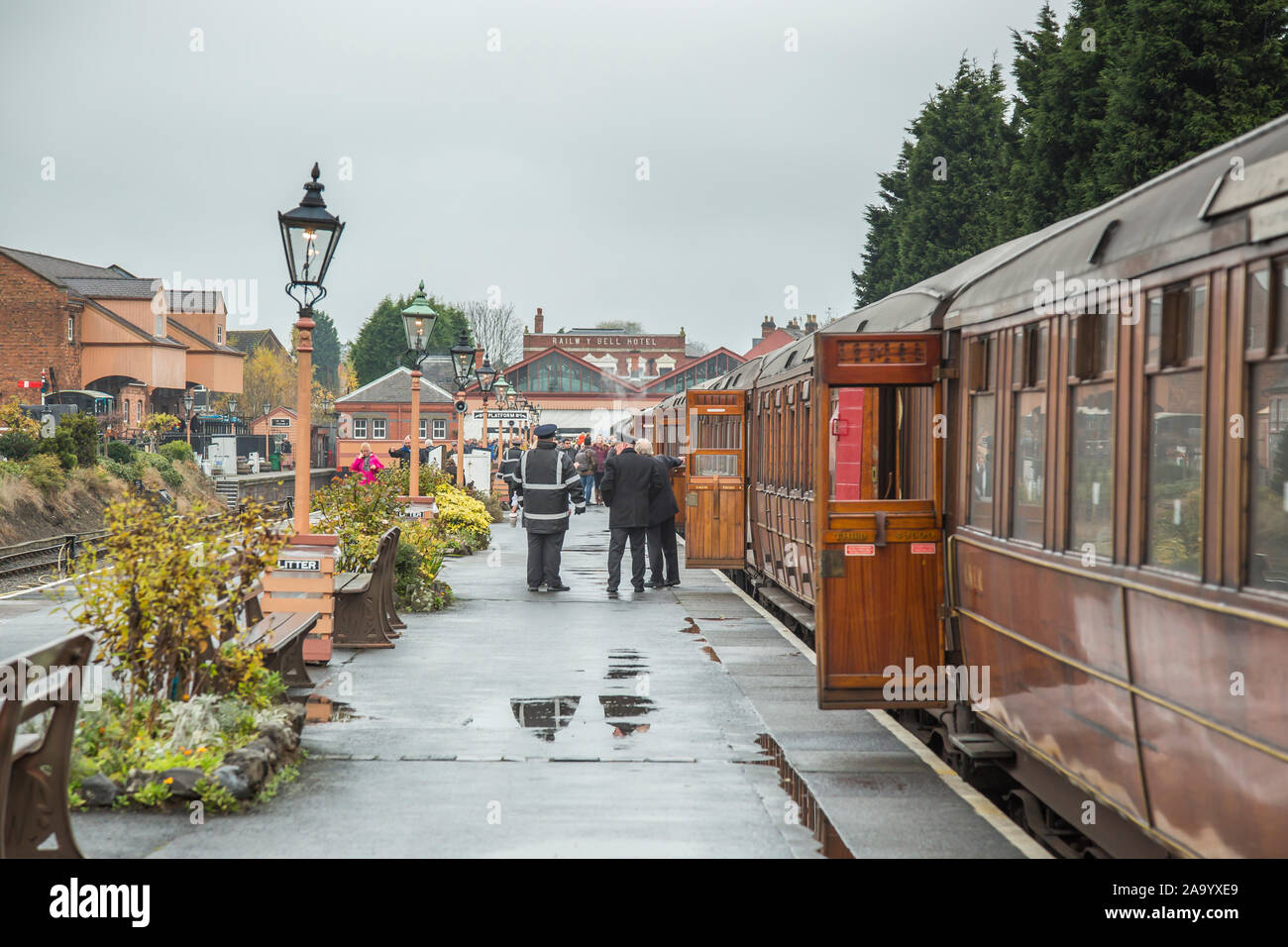 Sole dopo la pioggia: Scena della piattaforma mattutina, stazione ferroviaria d'epoca di Kidderminster, linea ferroviaria Severn Valley Railway Heritage, Regno Unito. Porte del treno vintage aperte. Foto Stock