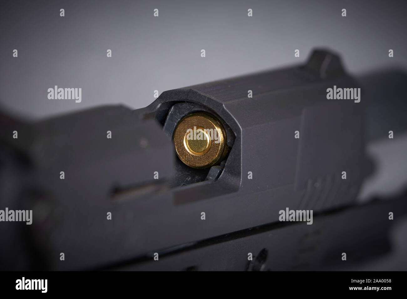 Primo piano di un proiettile nella camera di una pistola Foto Stock