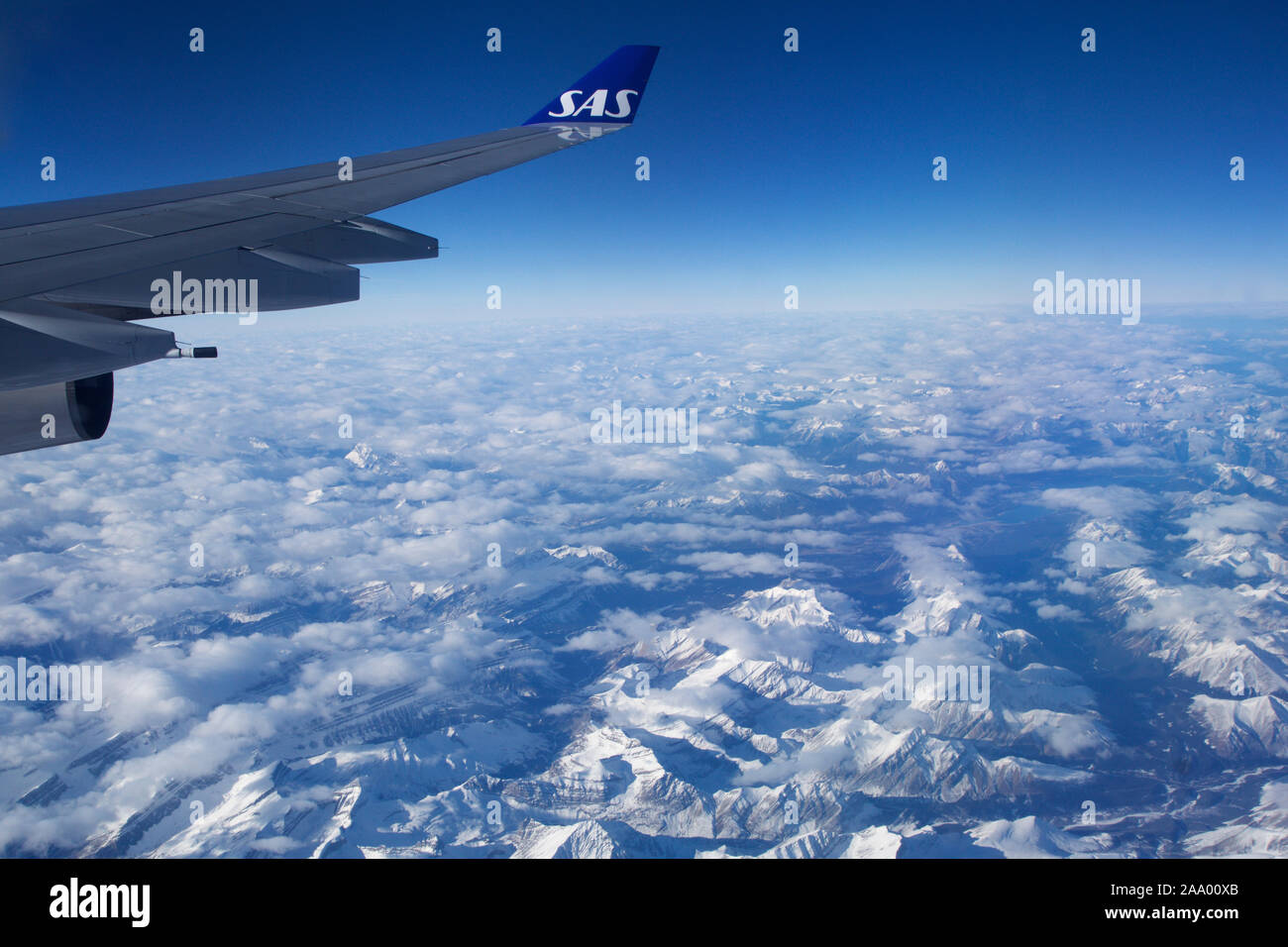 CANADA - Novembre 24th, 2018: una vista di un vasto paesaggio di montagne coperte di neve preso dalla finestra di un aereo che mostra l'ala Foto Stock