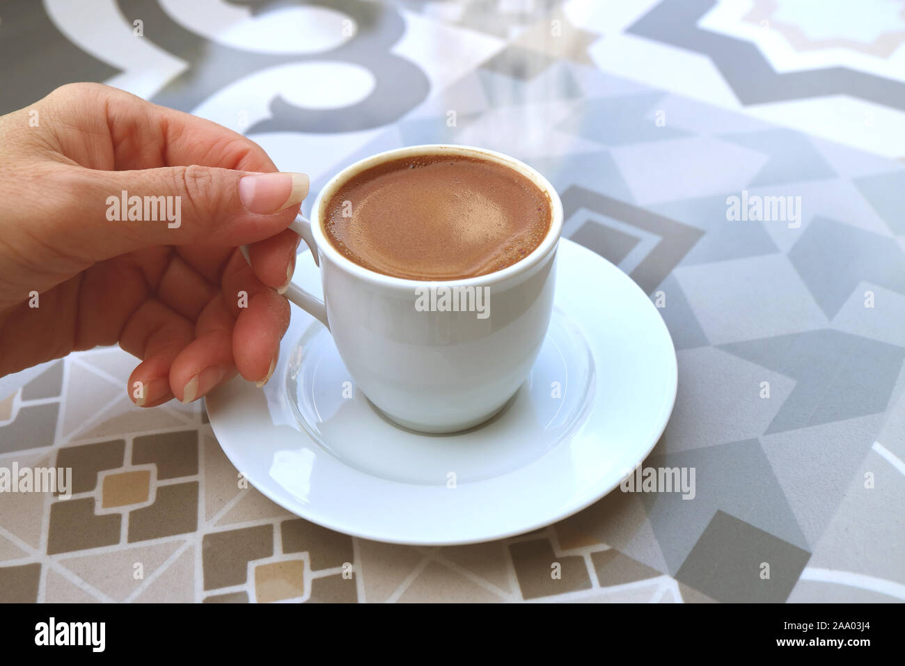 Donna di mano che regge una tazza di caffè turco servita su un modello di Moresco tabella Foto Stock