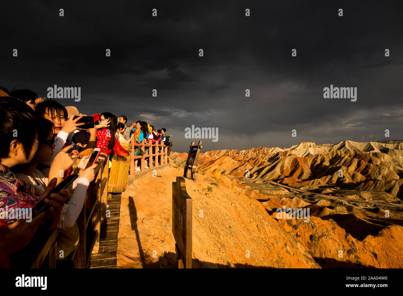 I turisti cinesi di visitare l'Arcobaleno montagne di Zhangye Danxia nazionale parco geologico Foto Stock