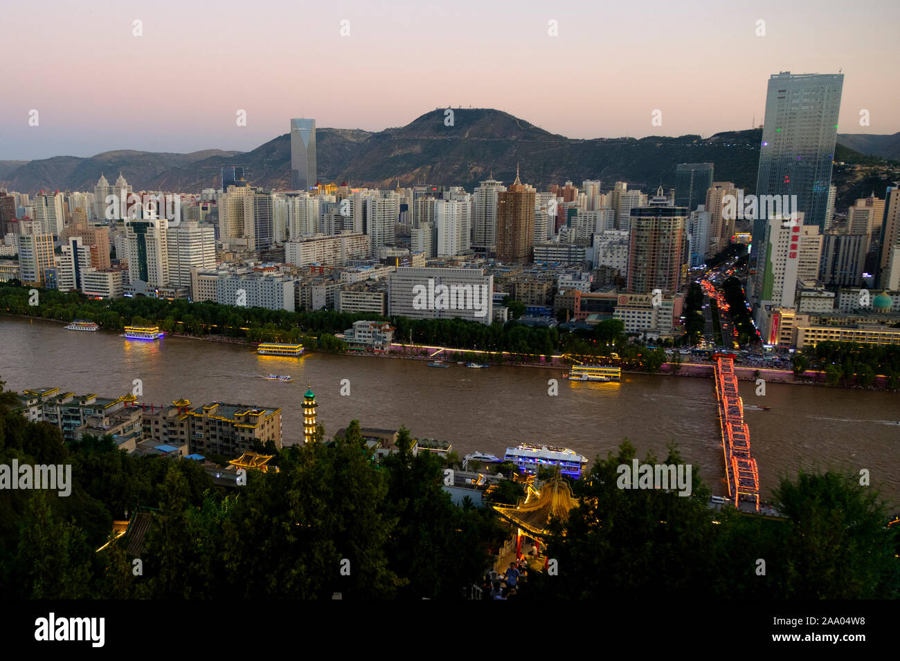 Il Fiume Giallo o Huang ha a Lanzhou con lo skyline della città al tramonto Foto Stock