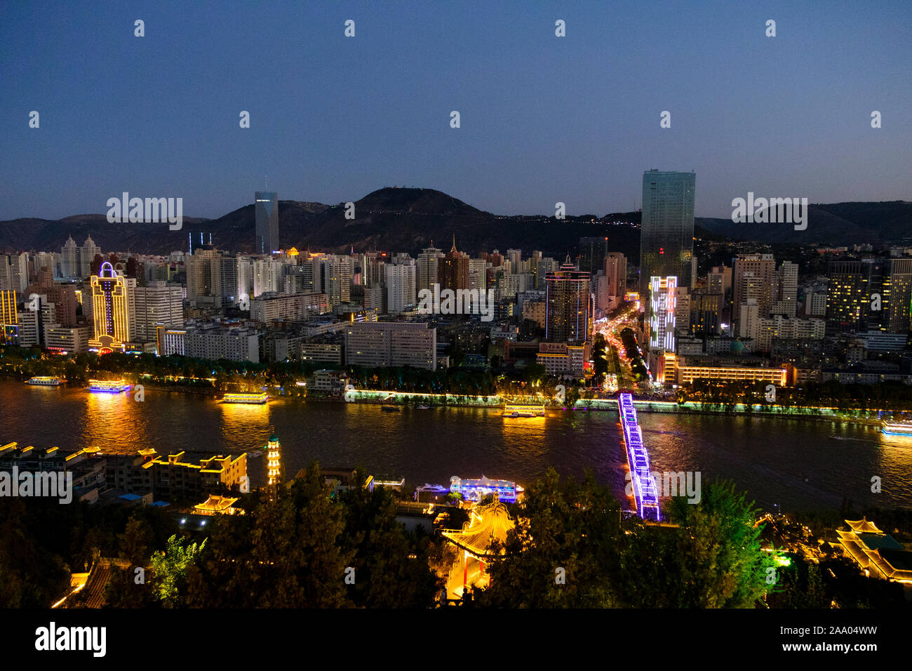Il Fiume Giallo o Huang ha a Lanzhou con lo skyline della città al tramonto Foto Stock