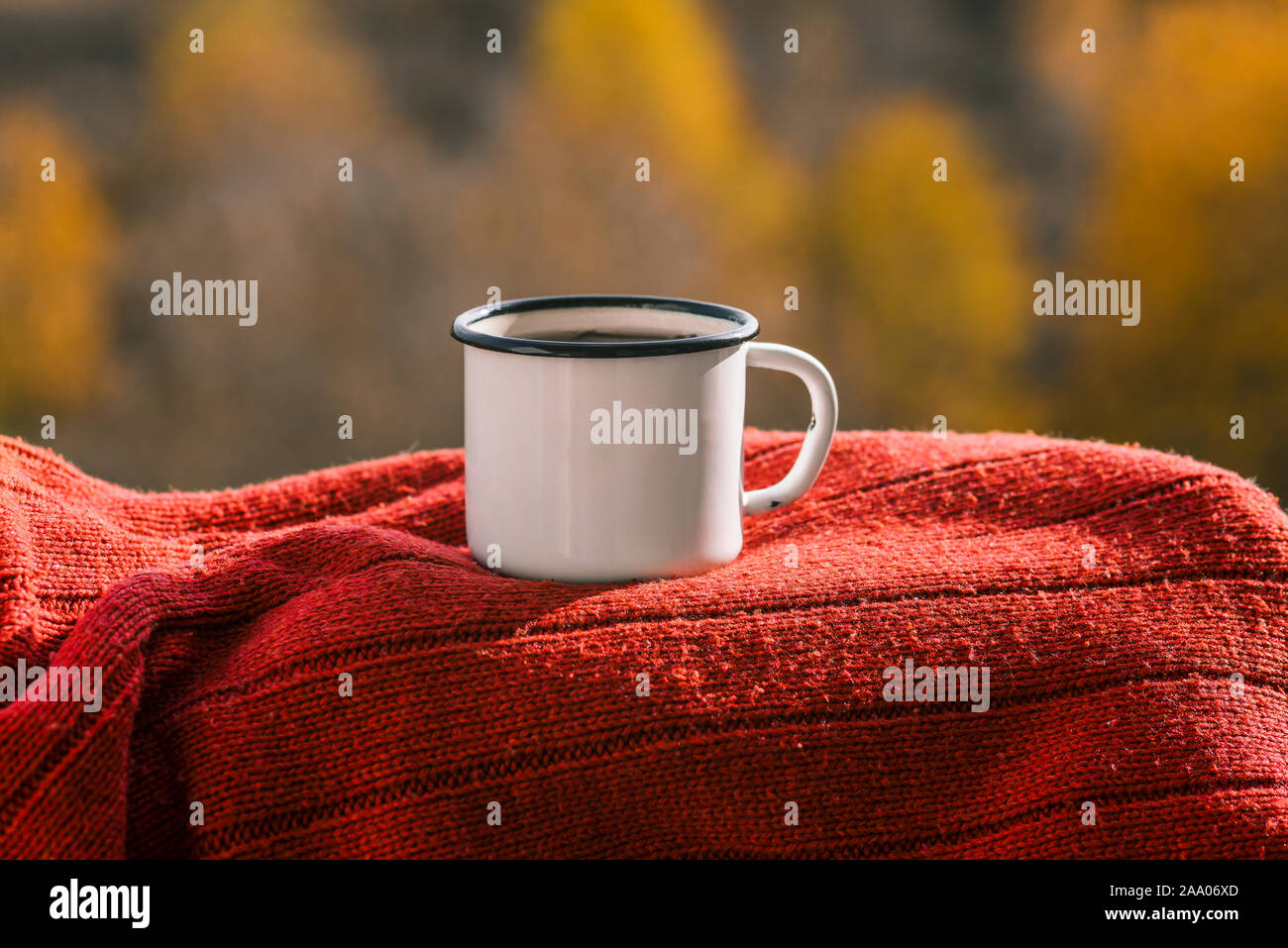 La tazza con il tè su un maglione rosso. Concetto di autunno e inverno si avvicina. Vestiti caldi. Foto Stock