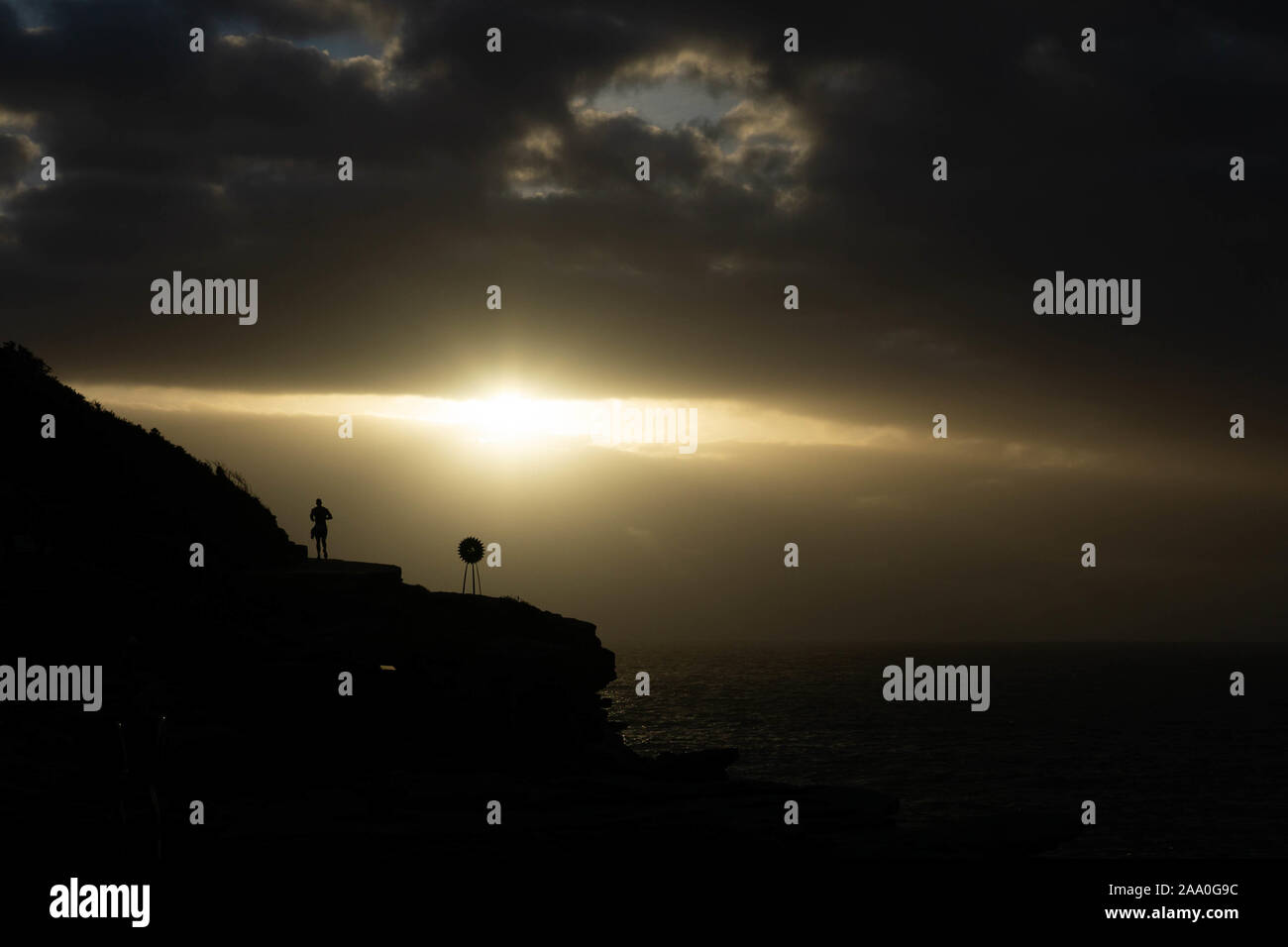 Silhouette di jogging sulla scogliera di sunrise, vicino al mare Foto Stock