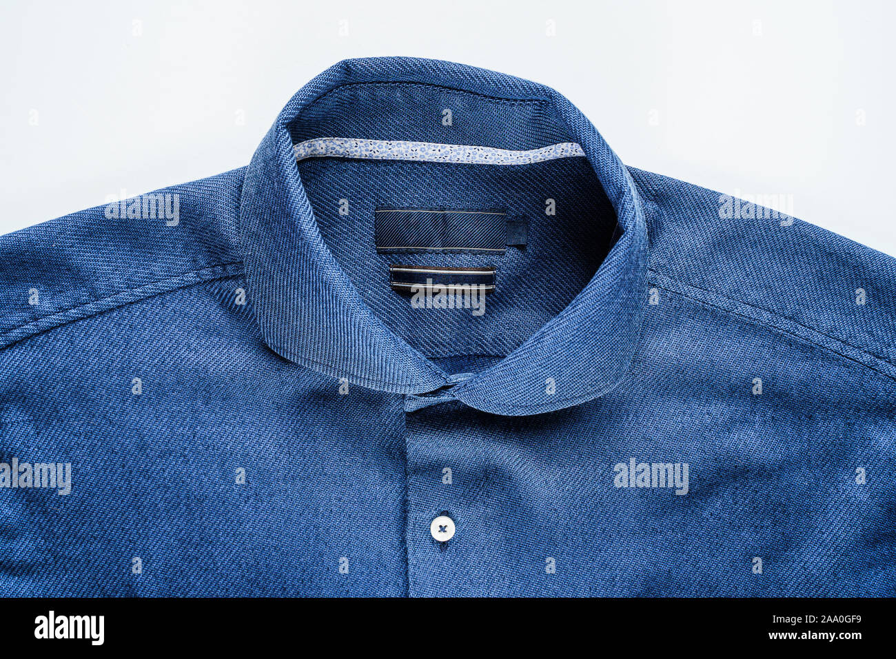 Blue Man Shirt su sfondo bianco. Sfondo di vestiti Foto Stock