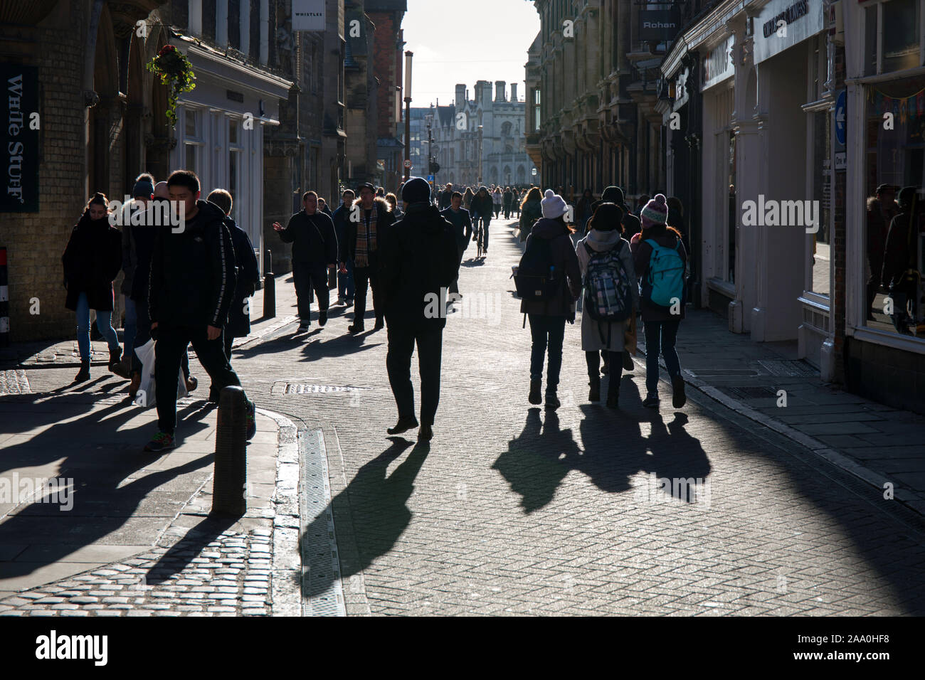 Folle di persone e ombre invernali su Trinity Street Cambridge Foto Stock