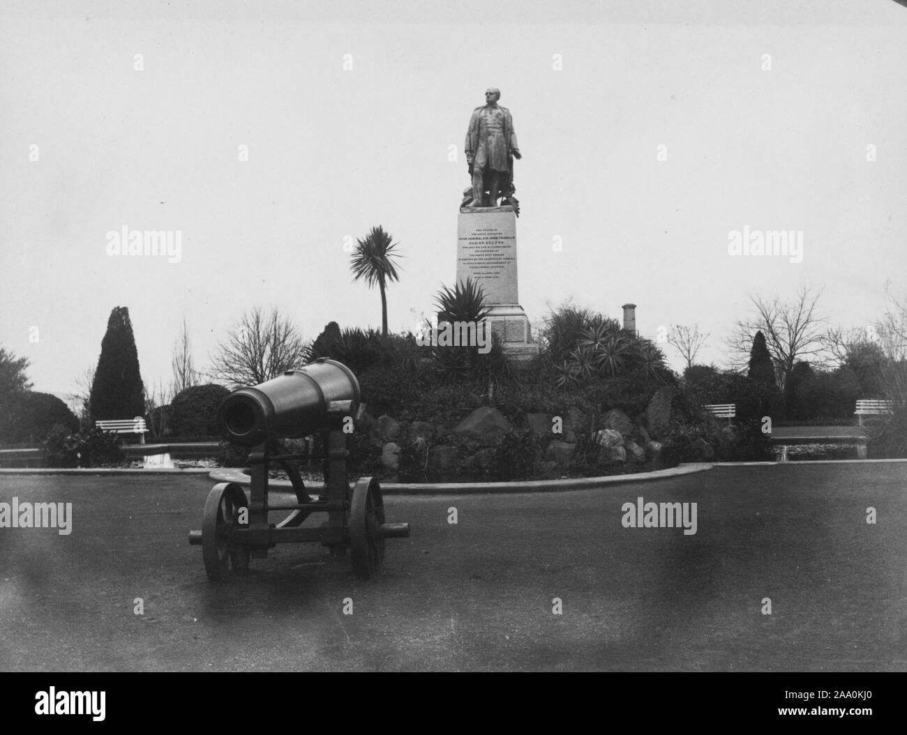 Fotografia in bianco e nero di un cannone e una statua del British Royal Navy officer e explorer dell'Artico, Ammiraglio Sir John Franklin di Franklin Square a Hobart, in Tasmania, Australia, dal fotografo Frank Coxhead, 1885. Dalla Biblioteca Pubblica di New York. () Foto Stock