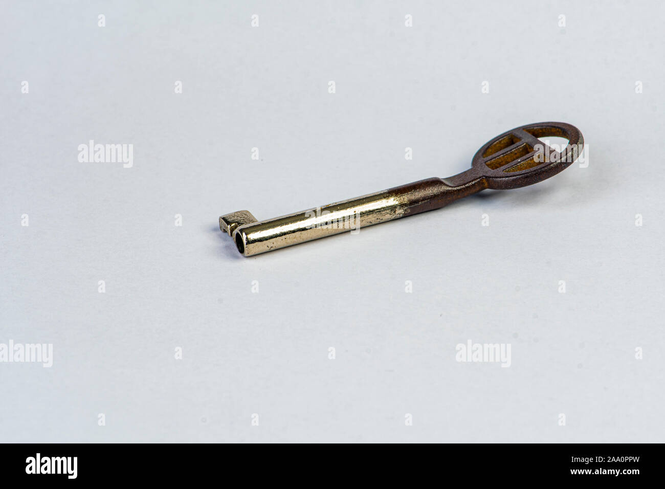 Vecchia chiave piegata ad un tesoro su sfondo bianco Foto Stock