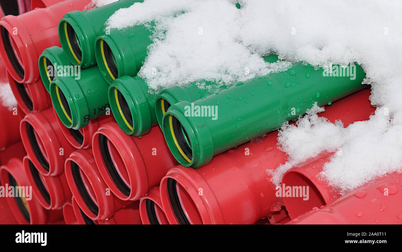 Metropolitana rossa e verde di service utility tubi ricoperti di neve. Elettricità tubi sotterranei Foto Stock