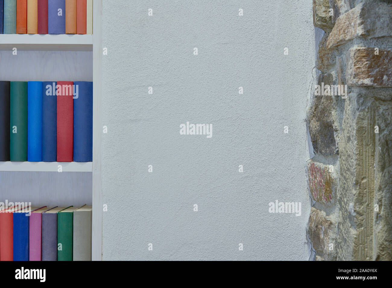 Muro Bianco e muro di pietra nel soppalco con libreria Foto Stock