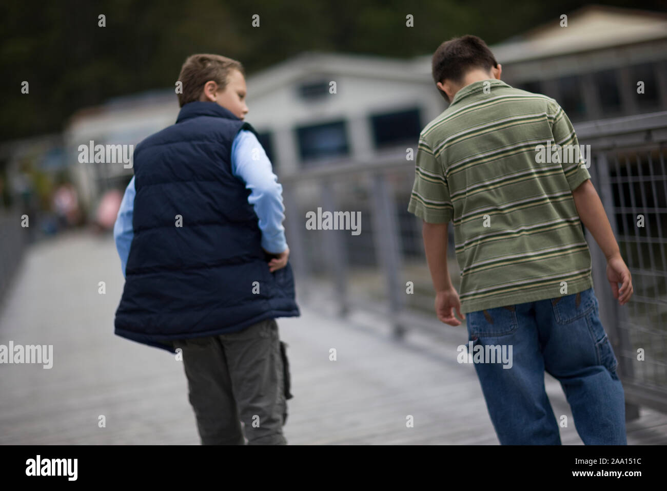 Due ragazzi avente una conversazione seria mentre si cammina lungo un pontile. Foto Stock