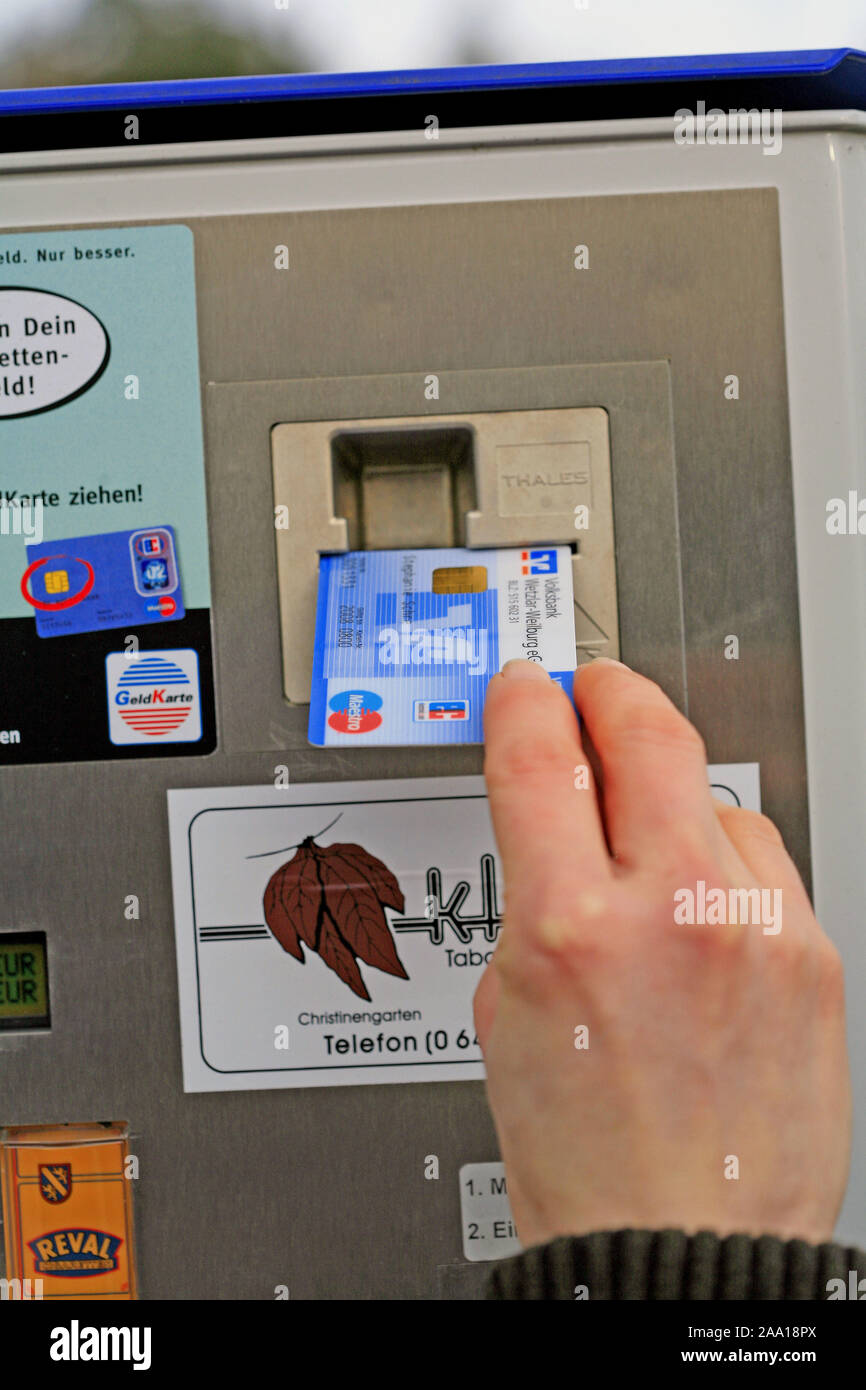 Eine EC-Karte wird zur Alterspr'fung in den Zigarettenautomat eingef'HRT / un cash card sarà inserito in una sigaretta automat per verificare l'età og t Foto Stock