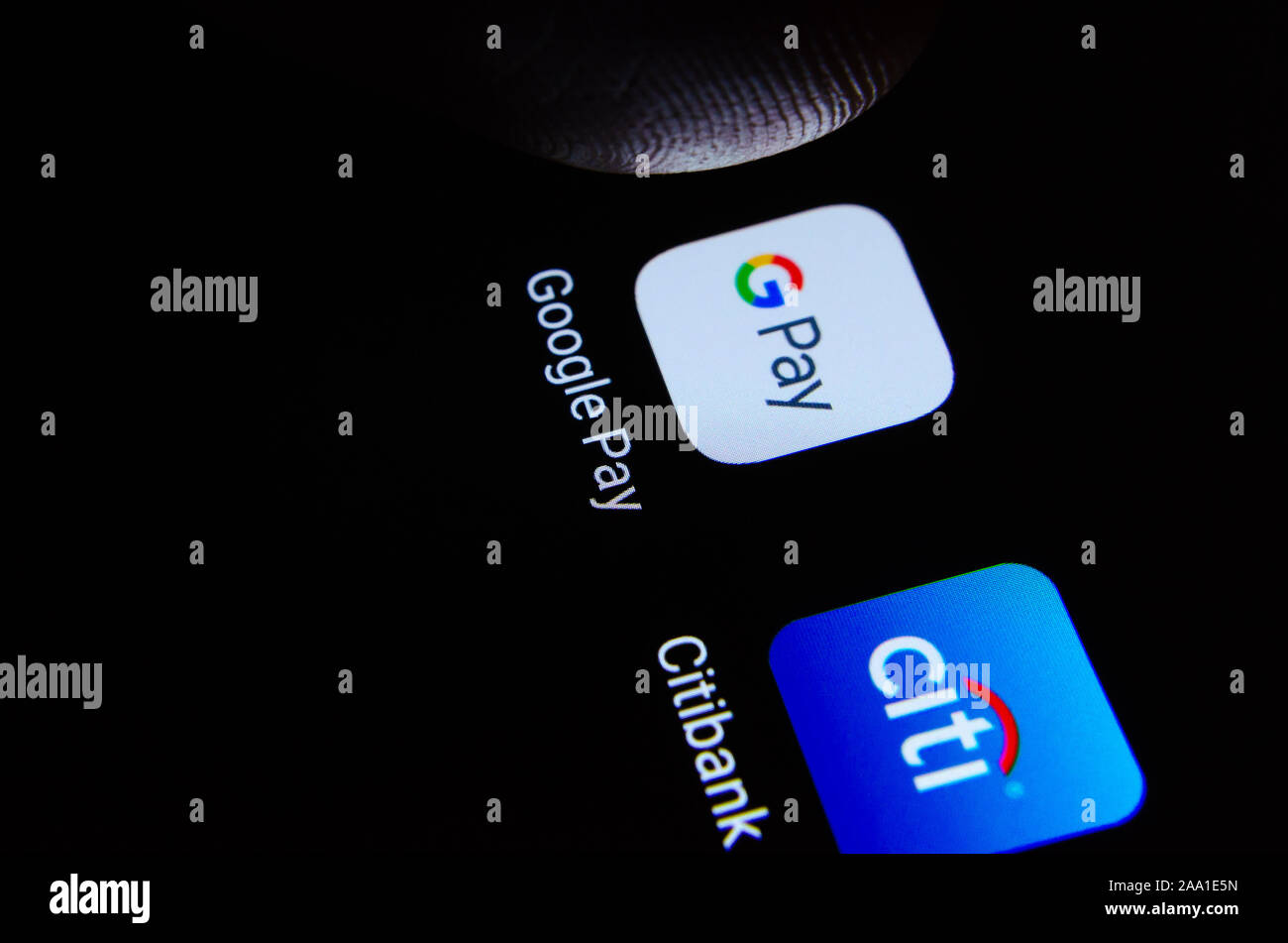 Google Pay e Citibank app su smartphone con la punta di un dito su Google Pay. A titolo illustrativo per Google e la Citibank di partenariato. Messa a fuoco selettiva Foto Stock