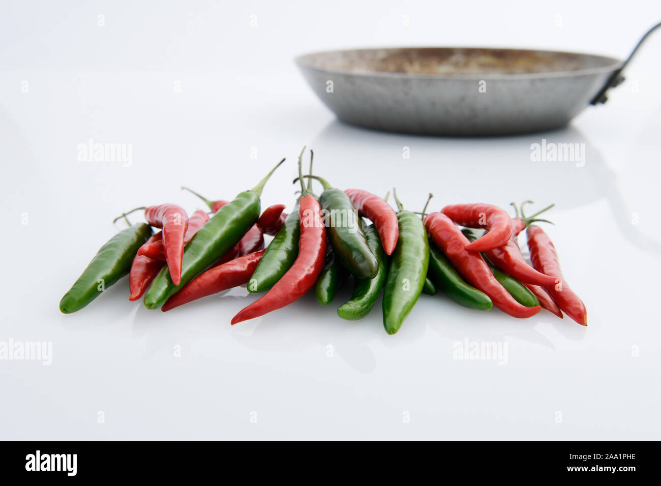 Close up, raccolta di rosso e peperoncini verdi con padella, preparazione alimentare, cucina casalinga, aroma ingrediente, still life Foto Stock