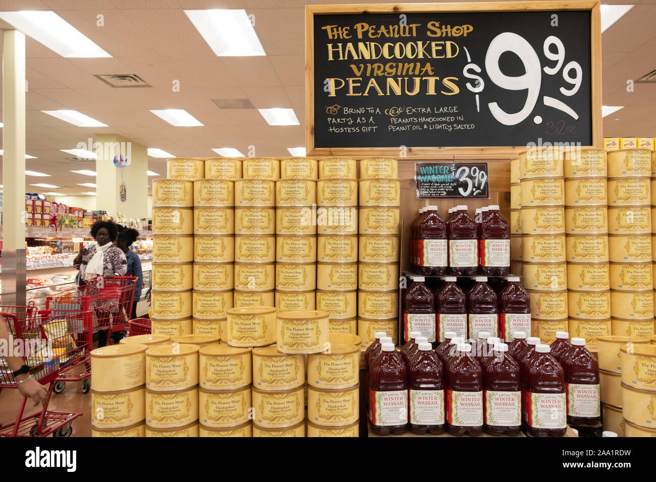 Un display di conserve handcooked Virginia arachidi e wassail all'interno di Trader Joe's, Wichita, Kansas, Stati Uniti d'America. I clienti in background. Foto Stock
