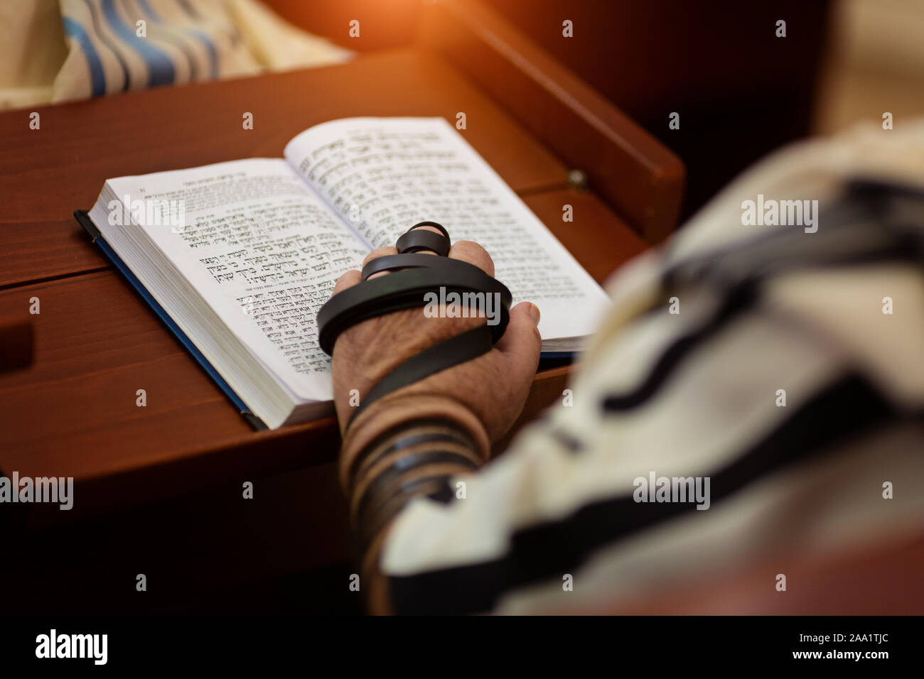 La lettura di preghiera ebraica e una mano con tefillin Foto Stock