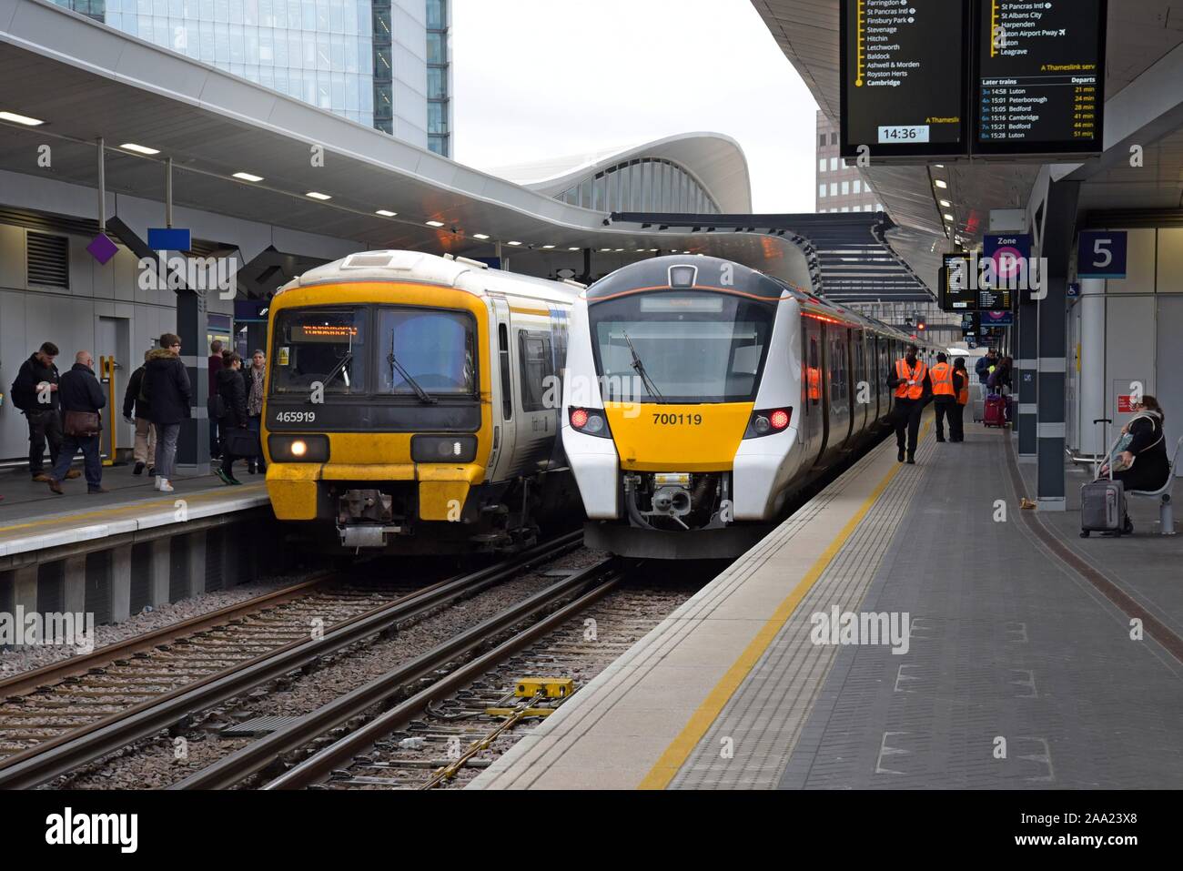 I passeggeri e il personale ferroviario a fianco di un Sud Est della classe 465 Networker e un Thameslink 700 classe Desiro visto presso la stazione di London Bridge Foto Stock